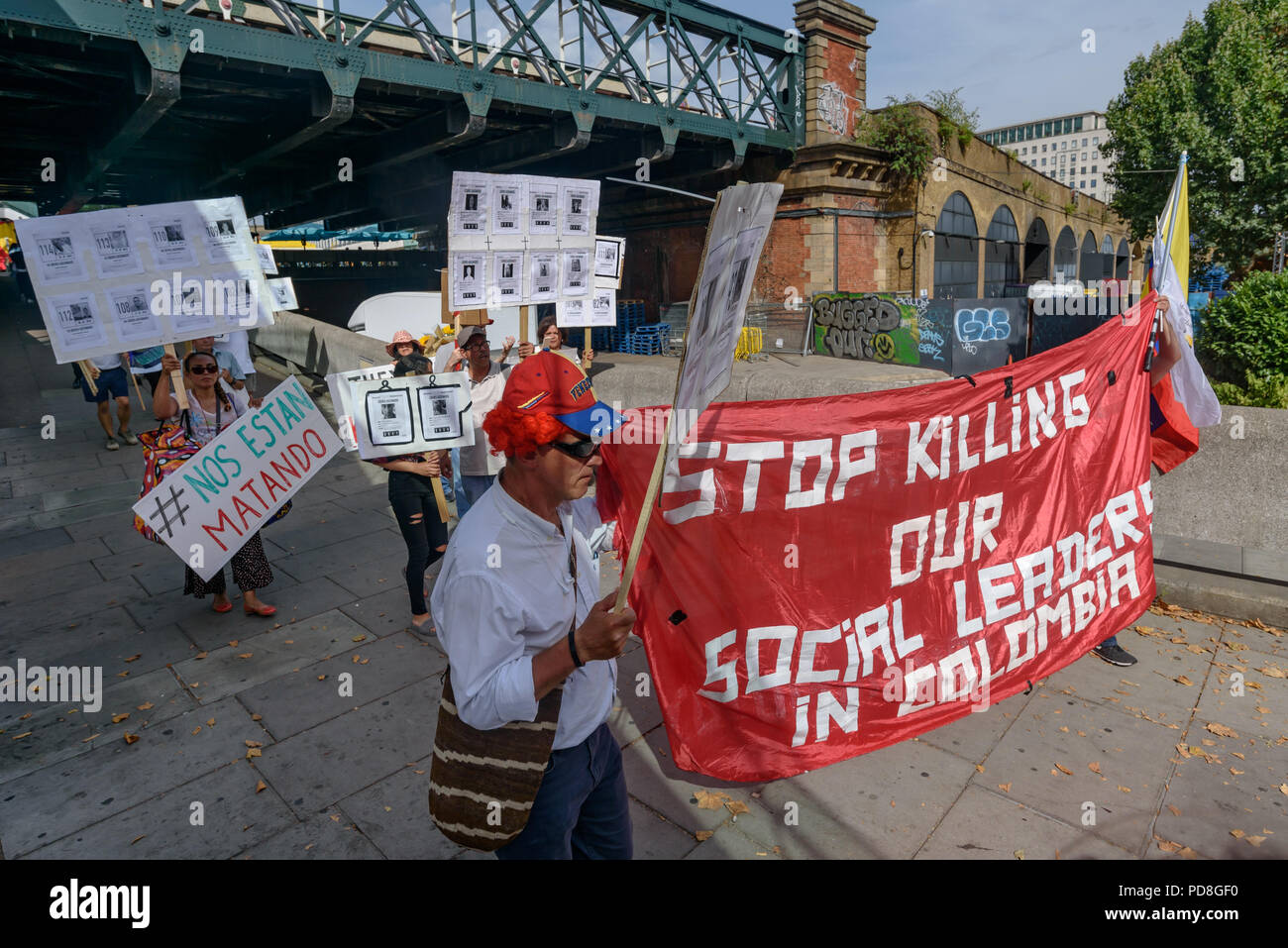 London, UK. 7th August 2018. Colombians and supporters of human rights walk with banners and Colombian flags and holding pictures of over a hundred murdered community leaders from the Southbank to Parliament Square in support of the peace process in Colombia and demanding an end to the daily threats and murders throughout the country. Credit: Peter Marshall/Alamy Live News Stock Photo