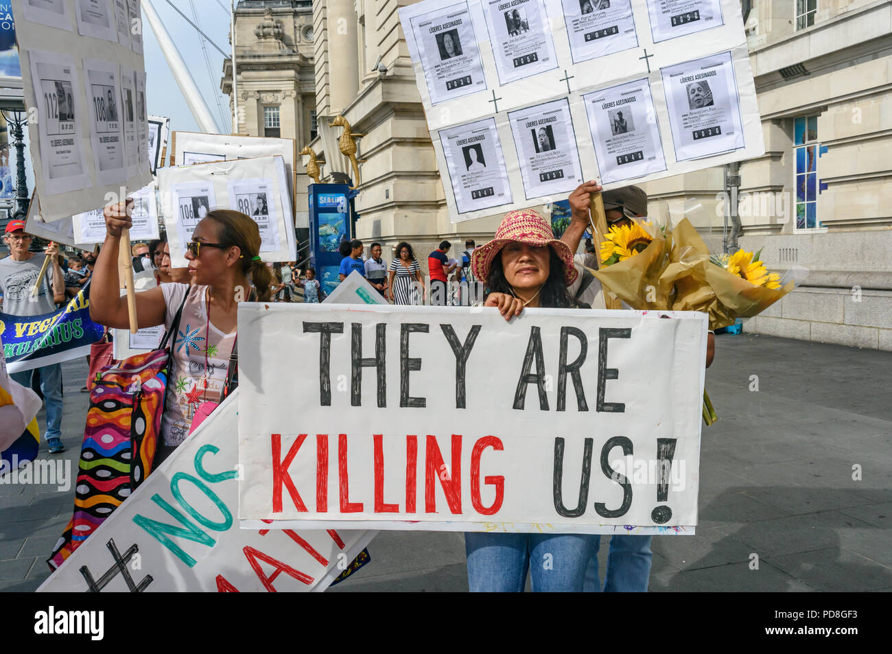 London, UK. 7th August 2018. Colombians and supporters of human rights walk with  posters and Colombian flags and holding pictures of over a hundred murdered community leaders from the Southbank to Parliament Square in support of the peace process in Colombia and demanding an end to the daily threats and murders throughout the country. The International Mobilization for Life and Peace called on the new President of Colombia to put into action an urgent plan to protect social leaders and rapidly implement the peace agreement. Similar actions in the International Mobilization for Life and Peace  Stock Photo