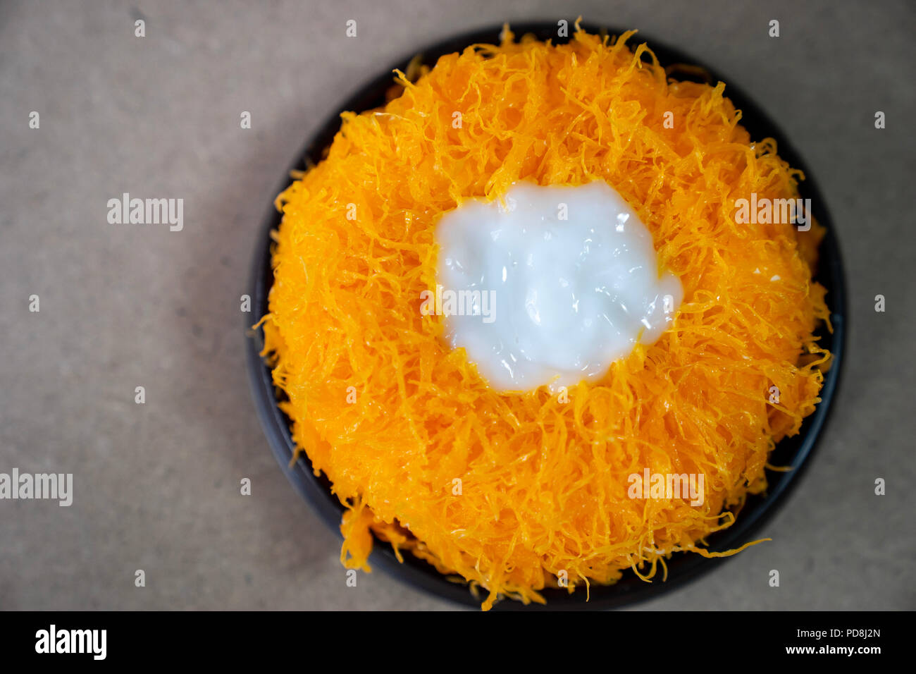 close up Top view Gold Egg Yolk Thread Cakes, or  'Cake Foi Tong' Thai cake isolated on brown cork table background with copy space Stock Photo