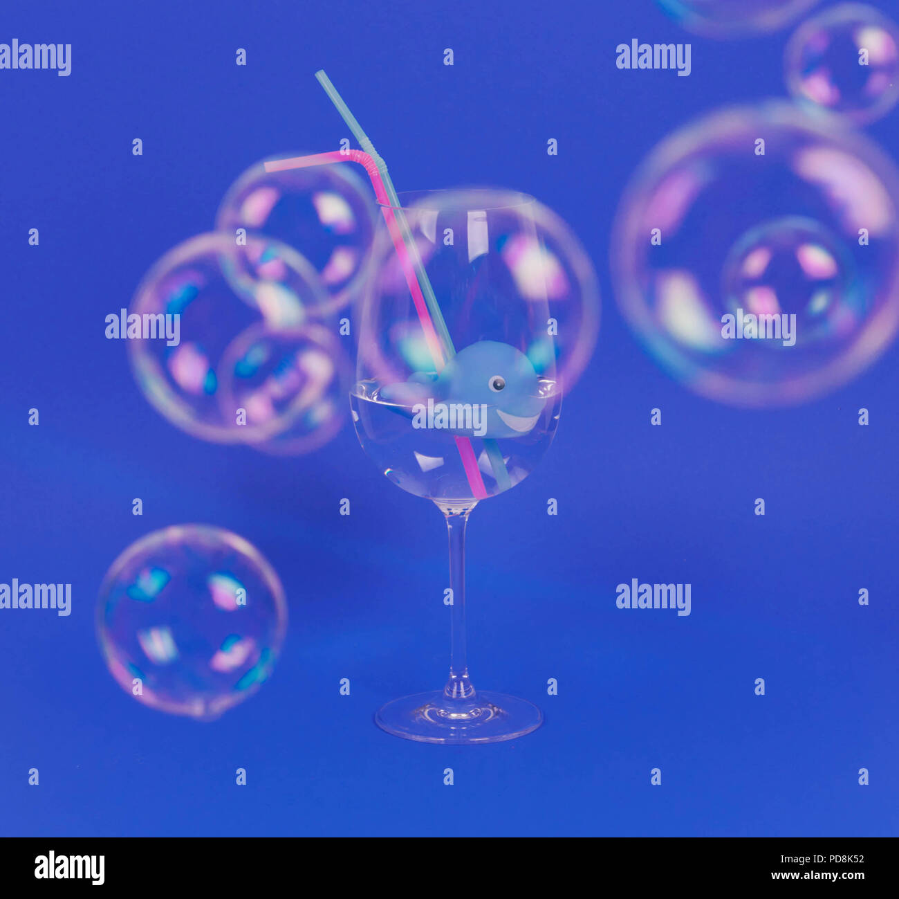 Whale in glass with water and plastic straws. Plastic pollution