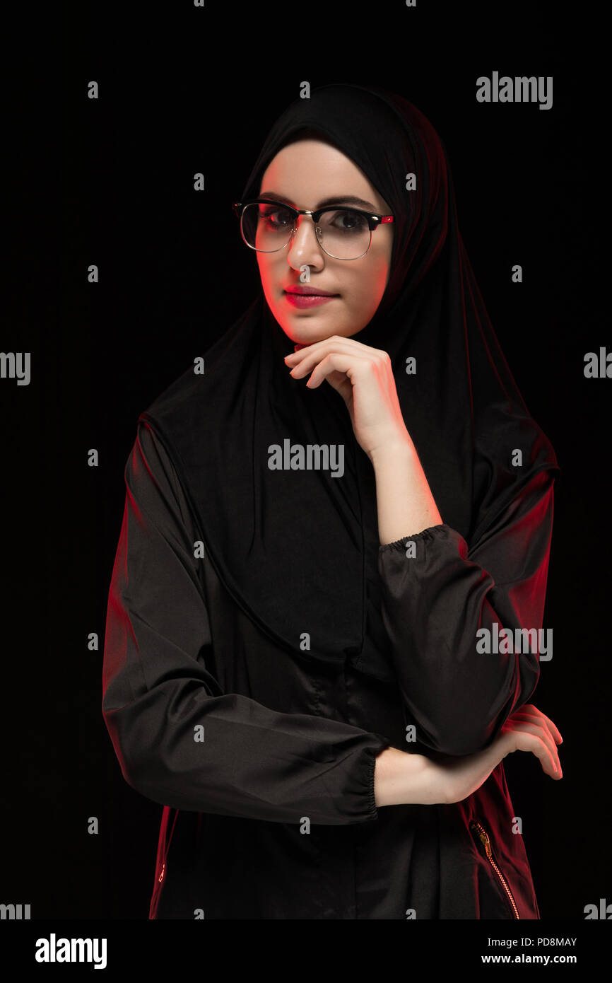 Portrait of beautiful trendy young muslim woman wearing black hijab and ...