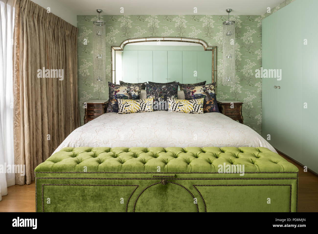 Lime green blanket box at foot of double bed Stock Photo