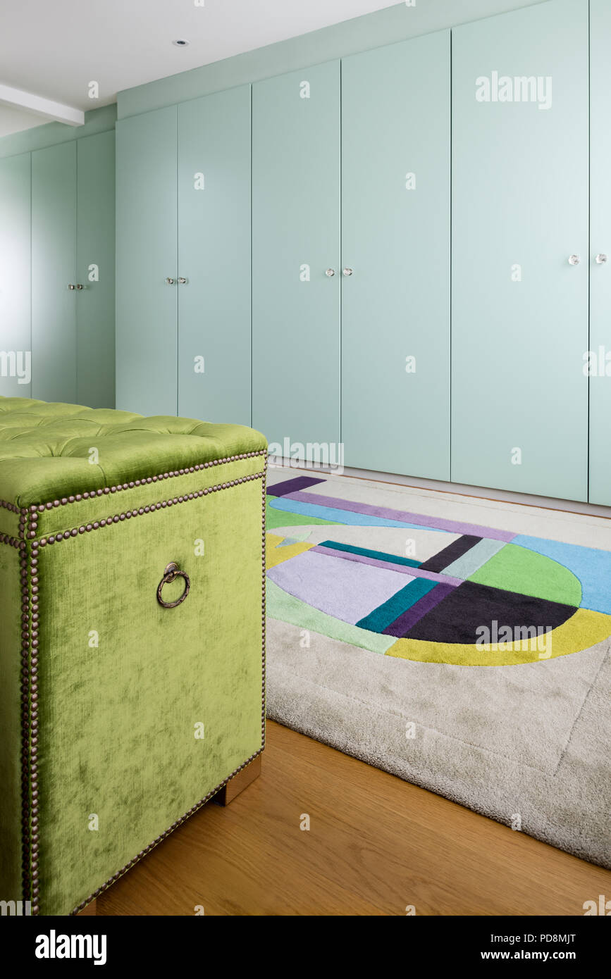 Lime green blanket box and wardrobes with rug Stock Photo