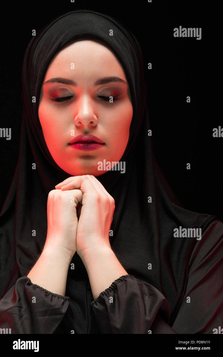 Portrait of beautiful serious young muslim woman wearing black hijab ...