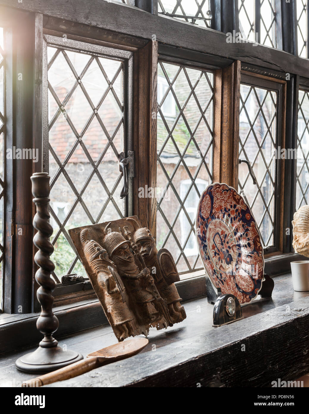 Decorative plate and ornaments on leaded glass windowsill Stock Photo