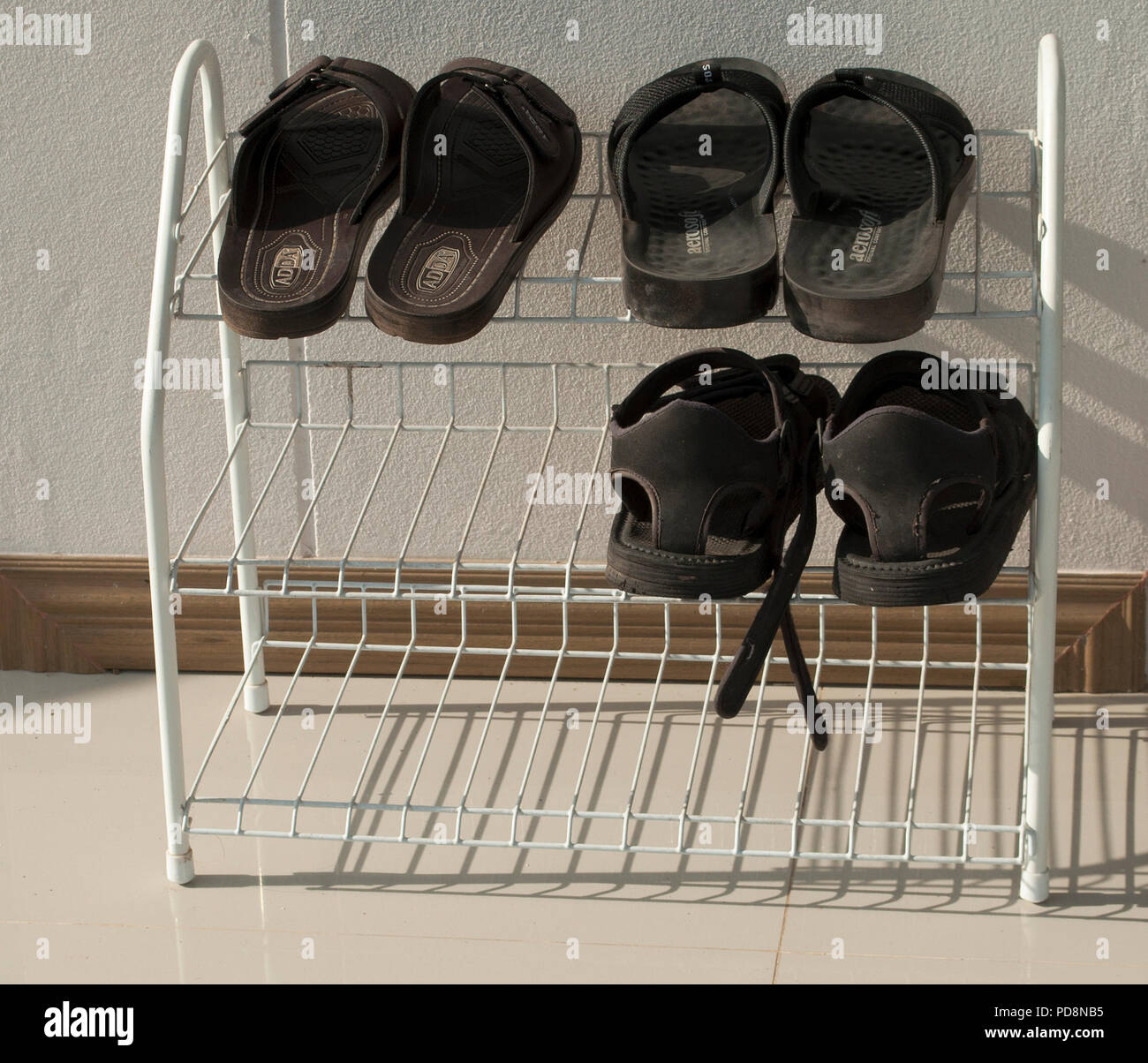 Brown and black sandals on a shoe rack Stock Photo