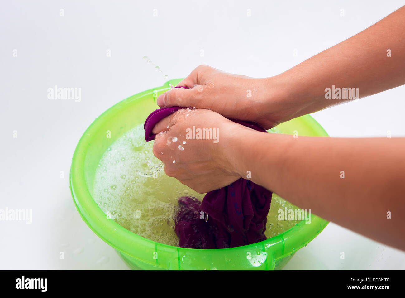 Photo of female hands washing laundry in green basin Stock Photo