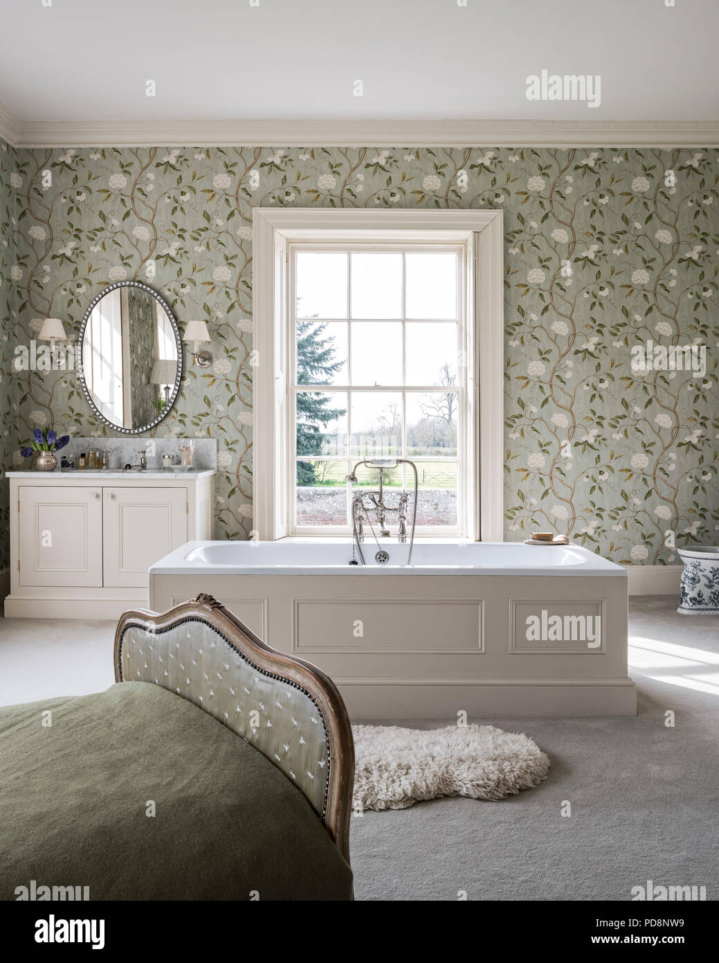 Antique daybed in floral papered ensuite bedroom Stock Photo