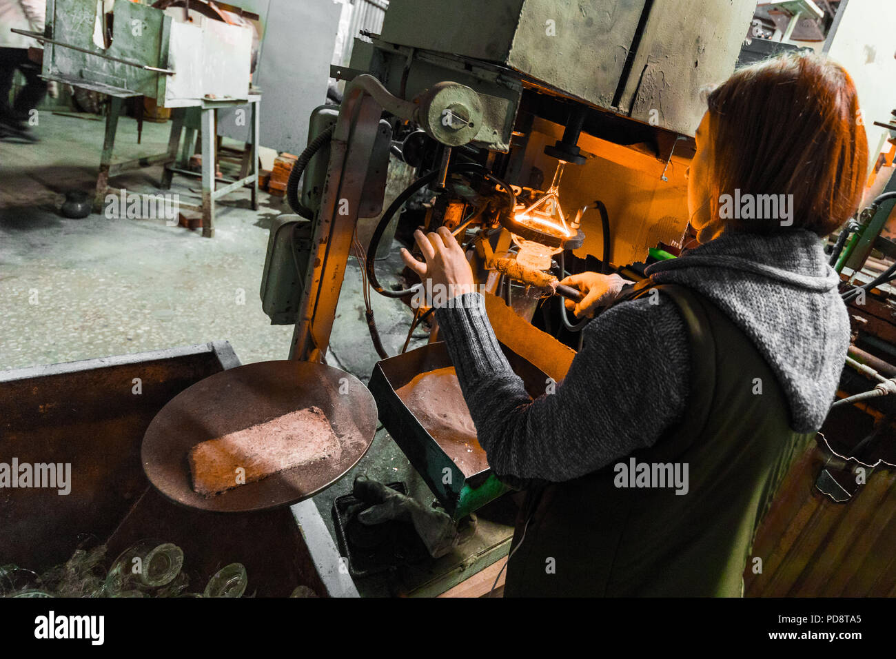 Glass production worker working with industry equipment on factory ...