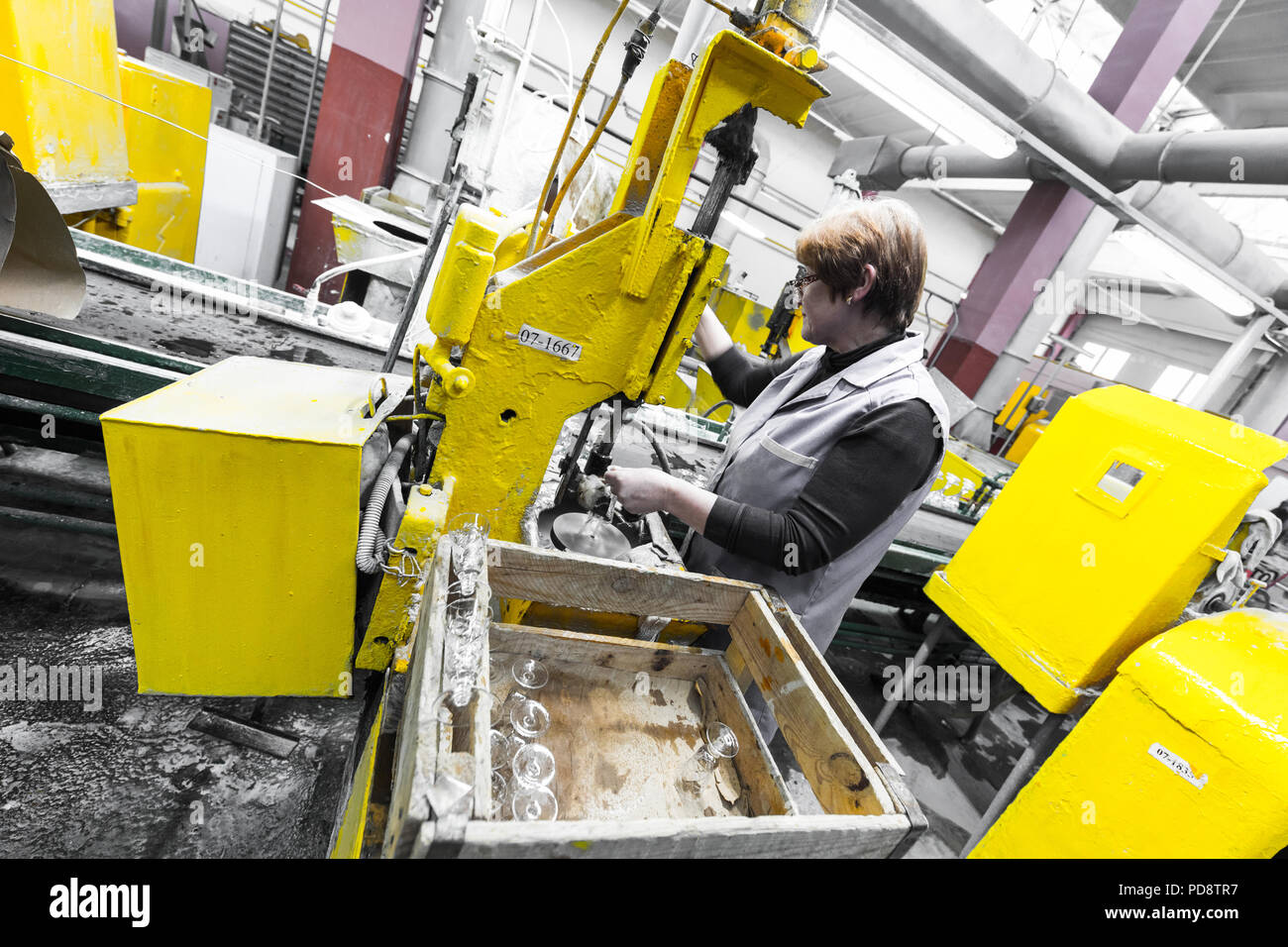 Glass production worker working with industry equipment on factory