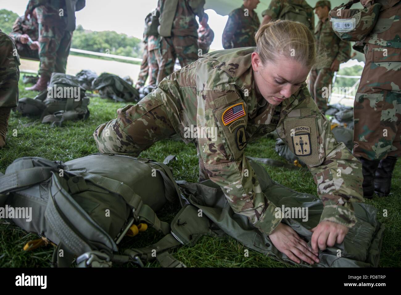 U.S. Army Staff Sgt. Charli Boyer, assigned to the Aerial Delivery and Field Services Department, U.S. Army Quartermaster School, prepares a parachute for the next day's jump during Leapfest at the University of Rhode Island, West Kingston, R.I. Aug. 4, 2018, August 4, 2018. Leapfest is the largest, longest standing, international static line parachute training event and competition hosted by the 56th Troop Command, Rhode Island Army National Guard to promote high level technical and esprit de corps within the International Airborne community. (U.S. Army photo by Sgt. Josephine Carlson). () Stock Photo