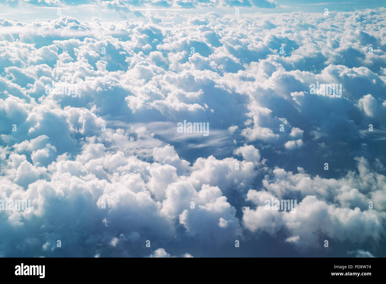 Aerial view from the plane of cumulus rain clouds. Dramatic cloudscape on the Heaven. Stock Photo