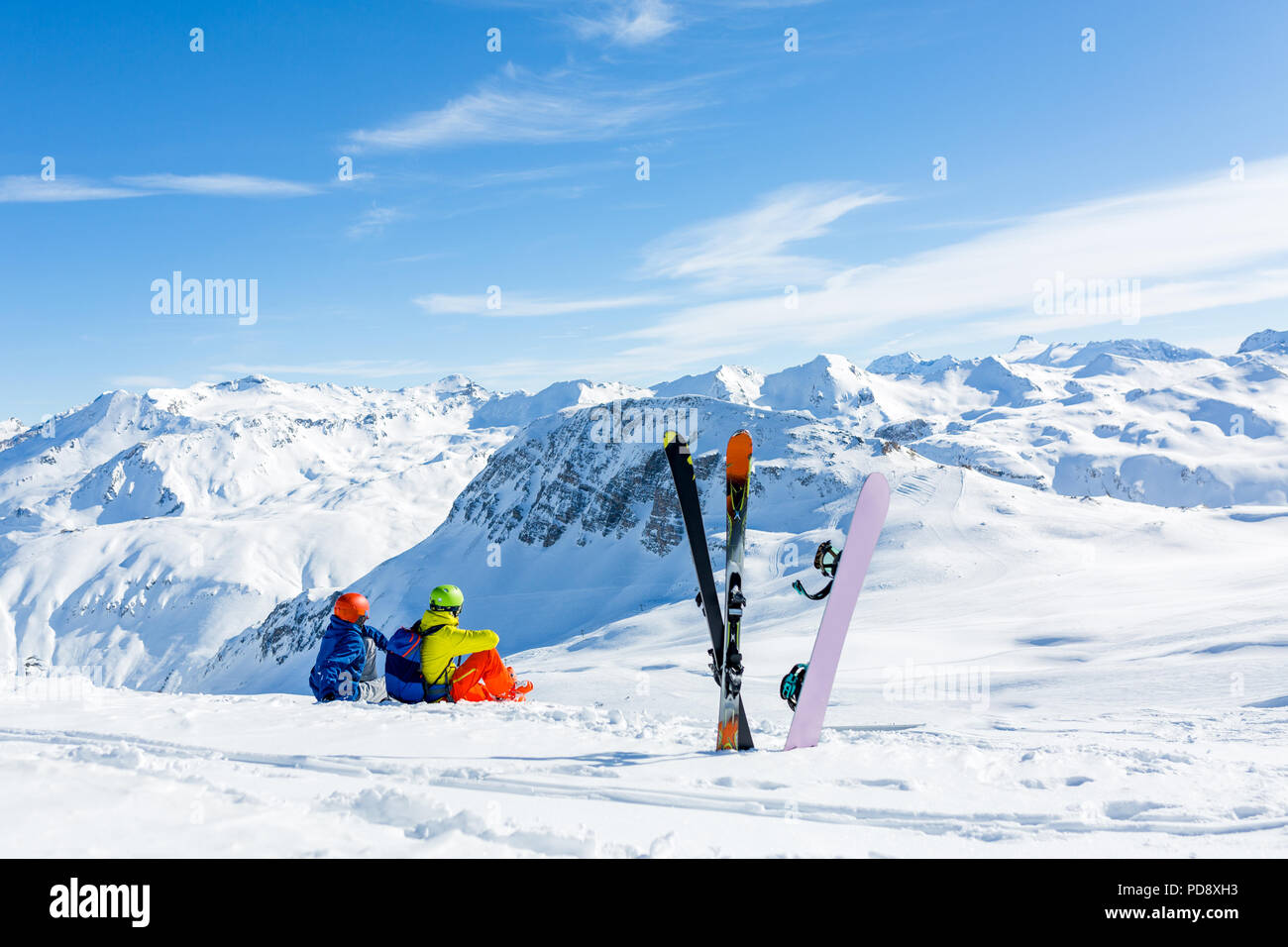 snowboarder and skiier sitting on snow and see at mountains Stock Photo