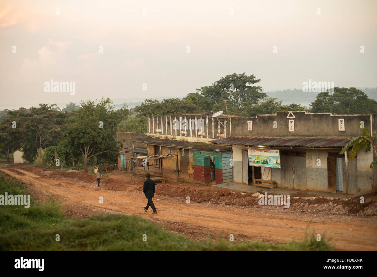 Shops and houses line the roadside of a small town in rural Mukono District, Uganda. Stock Photo