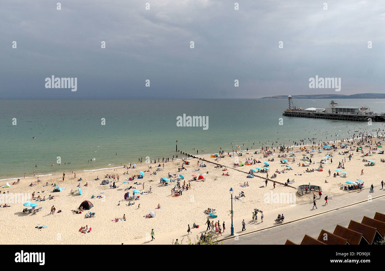 Storm clouds gather out at sea as people enjoy the warm weather on ...