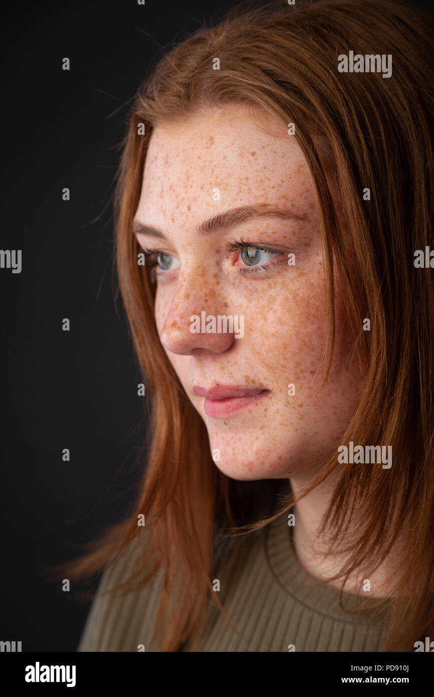 A profile headshot of a young woman with red hair and freckles Stock Photo