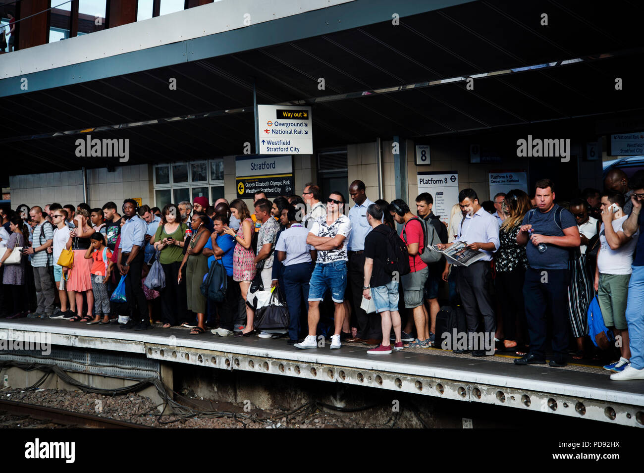 Stratford Station, London. Rush hour on a hot evening. Commuters wait for a delayed train to arrive Stock Photo