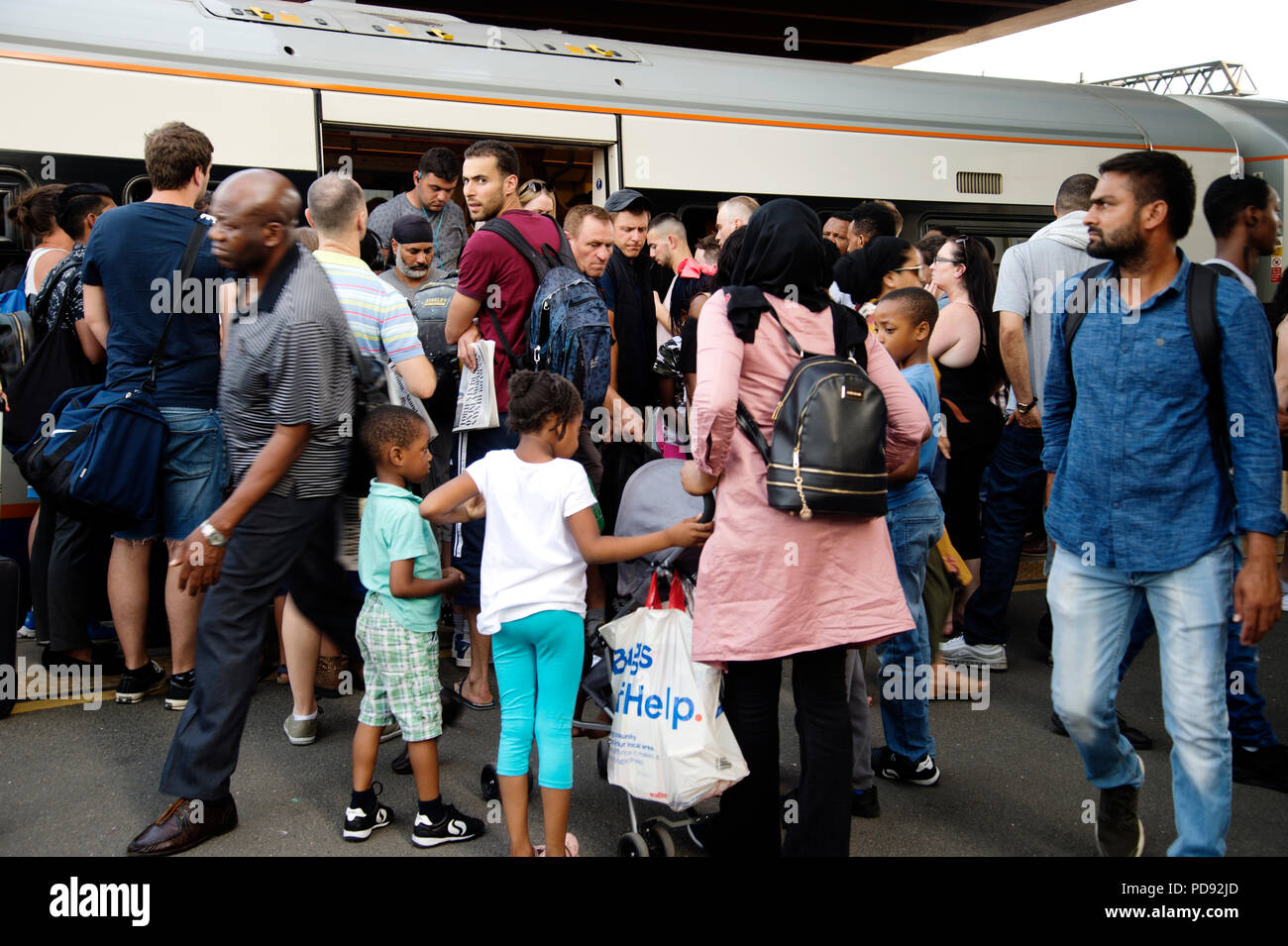 Stratford Station, London. Rush hour on a hot evening. Passengers board a train on the Overground Stock Photo