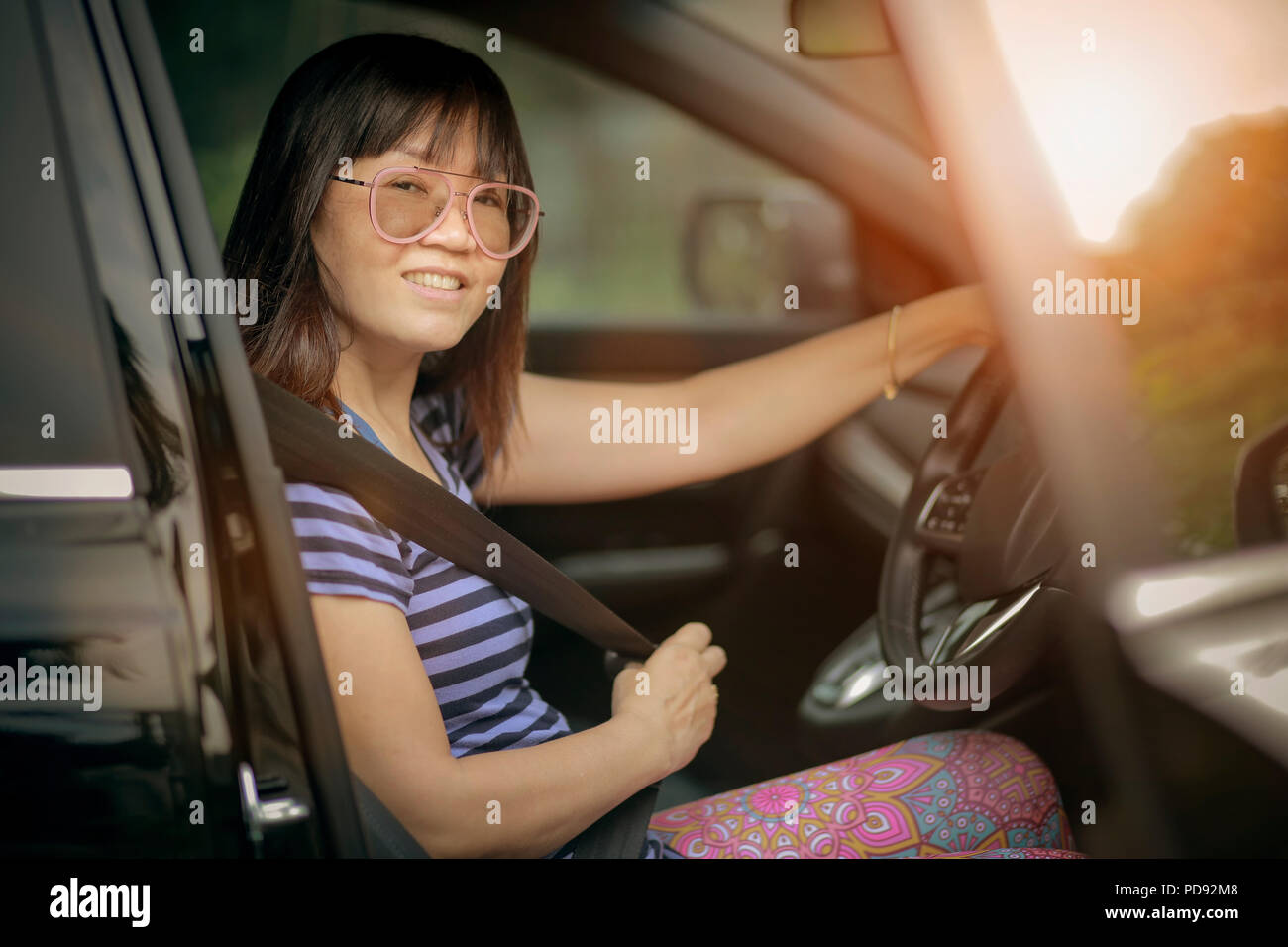 asian woman driving personal car toothy smiling face Stock Photo