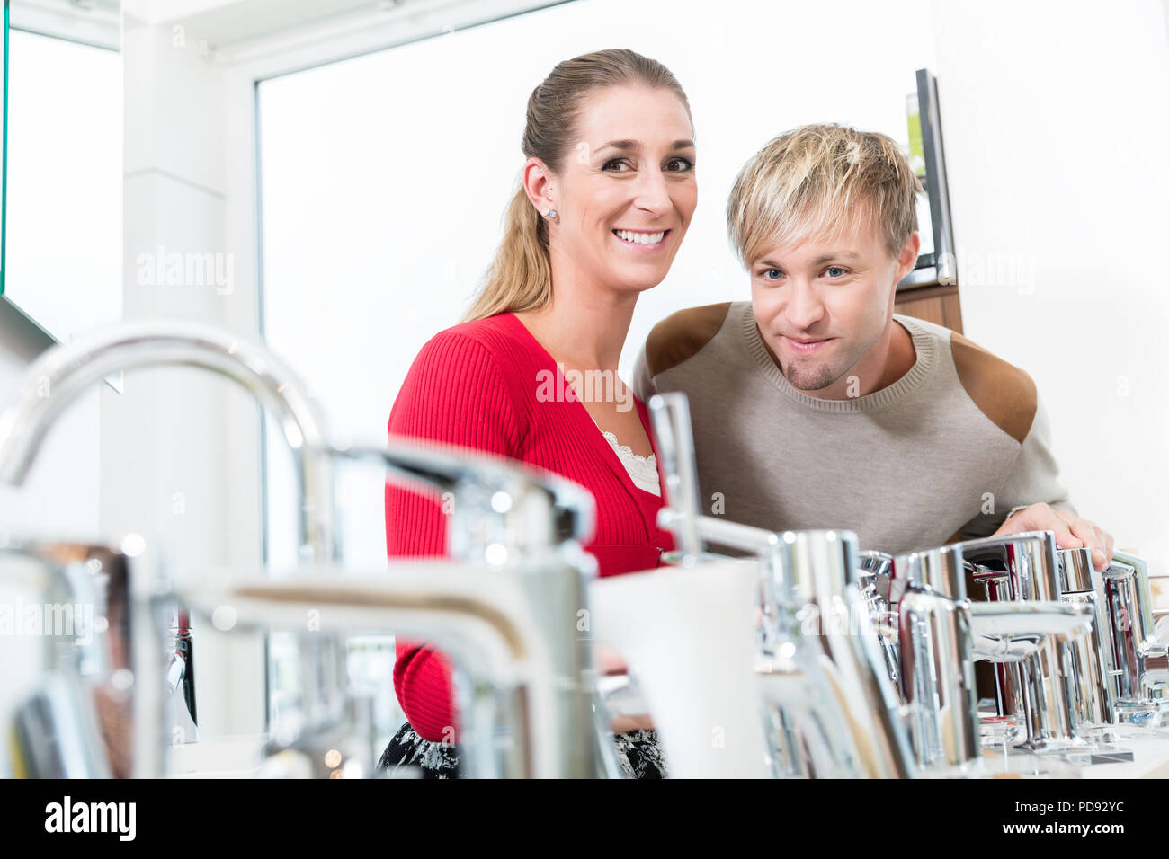 Happy couple choosing a new faucet in a modern sanitary ware shop Stock Photo