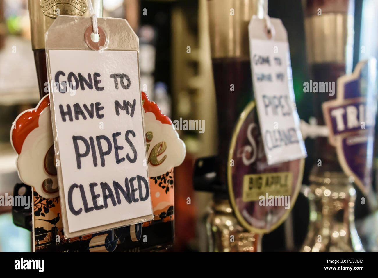 Signs on beer pumps in a British pub advising customers that the beer is not available as the pipes are being cleaned. Stock Photo
