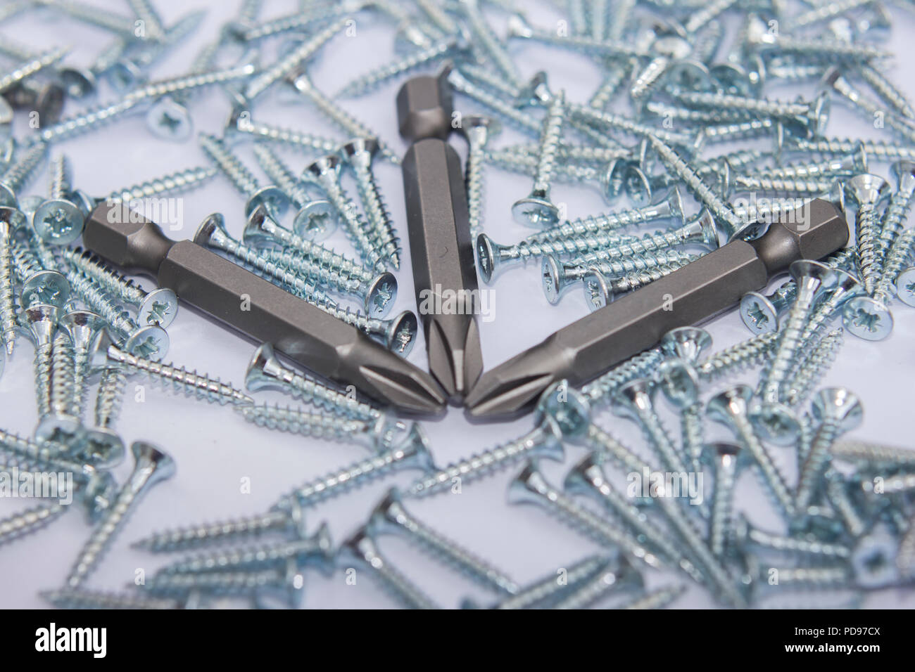 A pattern background of Pozidriv screws and screw bits Stock Photo