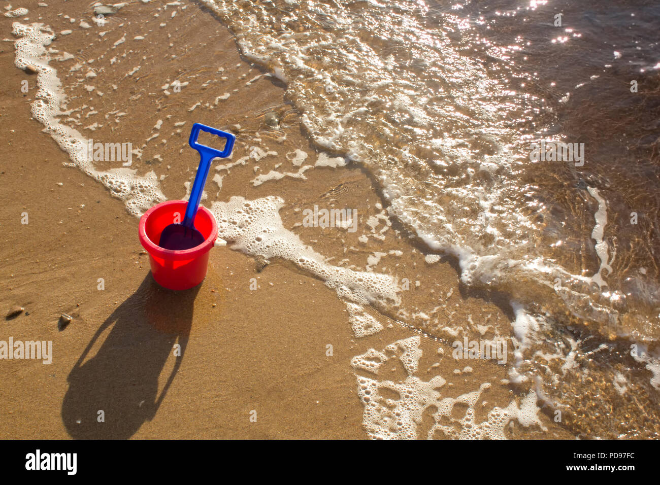 A bucket and spade sitting on a sandy beach during a sunny day in Sutherland, Highlands Scotland. Stock Photo