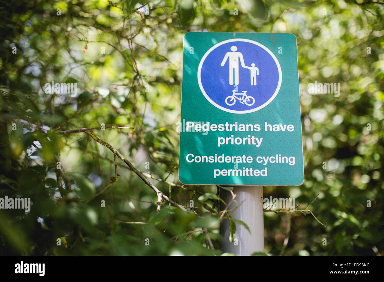 The Parkland Walk is a linear green pedestrian & cycle route. Pedestrians have right of way whilst walking, this sign asks cyclists to be considerate Stock Photo