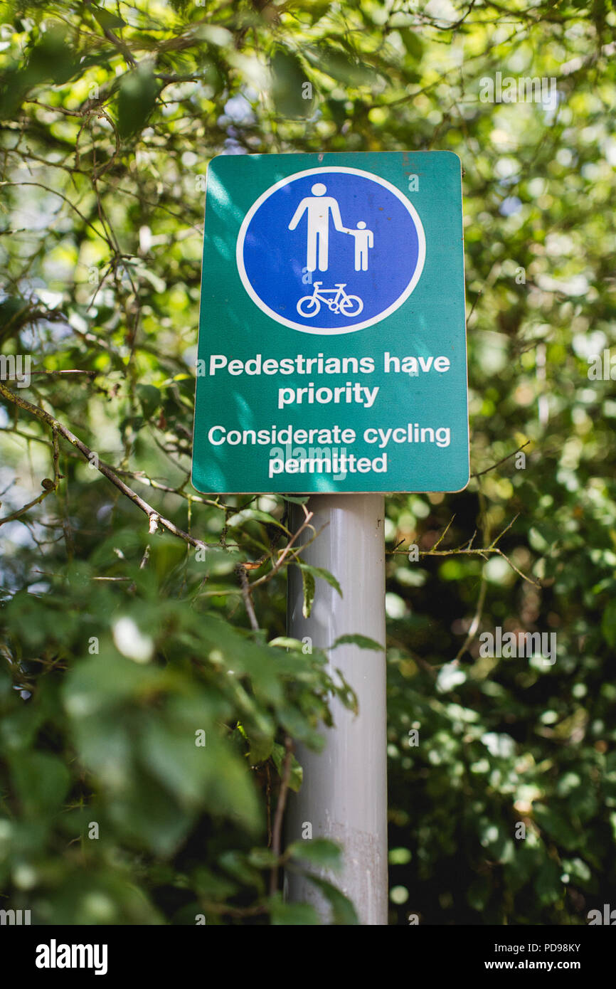 The Parkland Walk is a linear green pedestrian & cycle route. Pedestrians have right of way whilst walking, this sign asks cyclists to be considerate Stock Photo