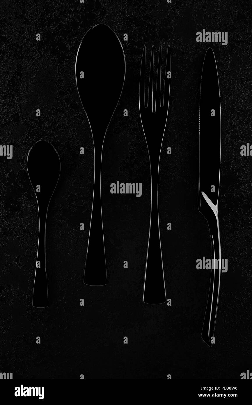 Black cutlery on black table, top view. Stock Photo