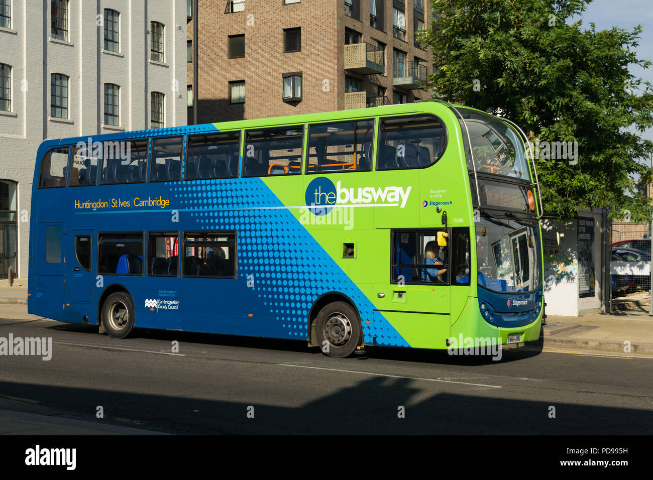 A Cambridge busway bus driving along Station Place road in Cambridge on a Summer morning, Cambridge, UK Stock Photo