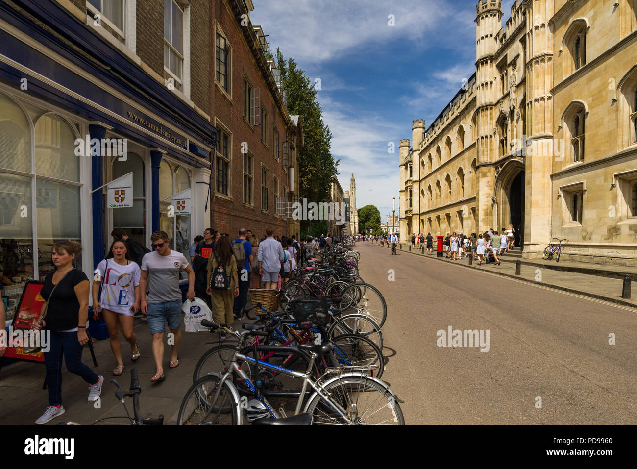 Exterior of Corpus Christi College and shops from Trumpington Street with people walking on pavement outside, Cambridge, UK Stock Photo