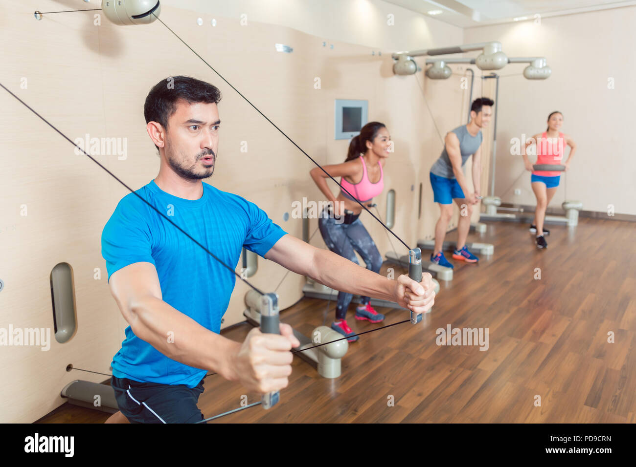Determined young man exercising with resistance bands Stock Photo