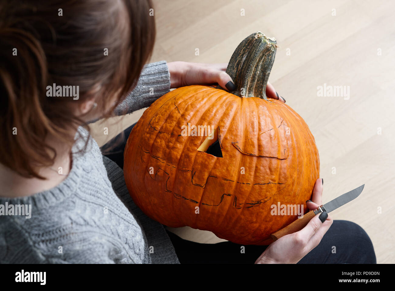 Carving halloween pumpkin into jack-o-lantern, close up view Stock Photo