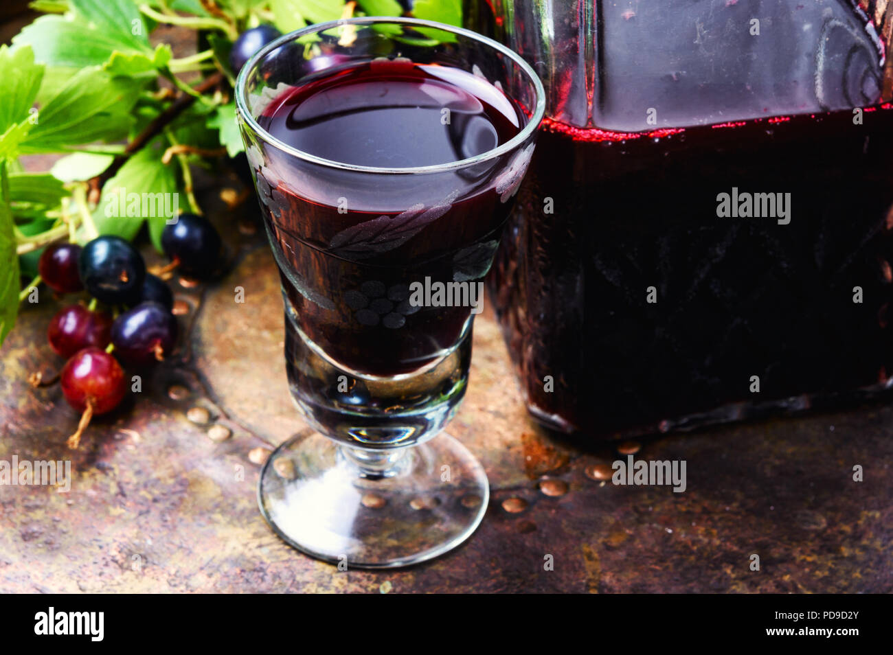 Glass with homemade liqueur from black currant Stock Photo - Alamy