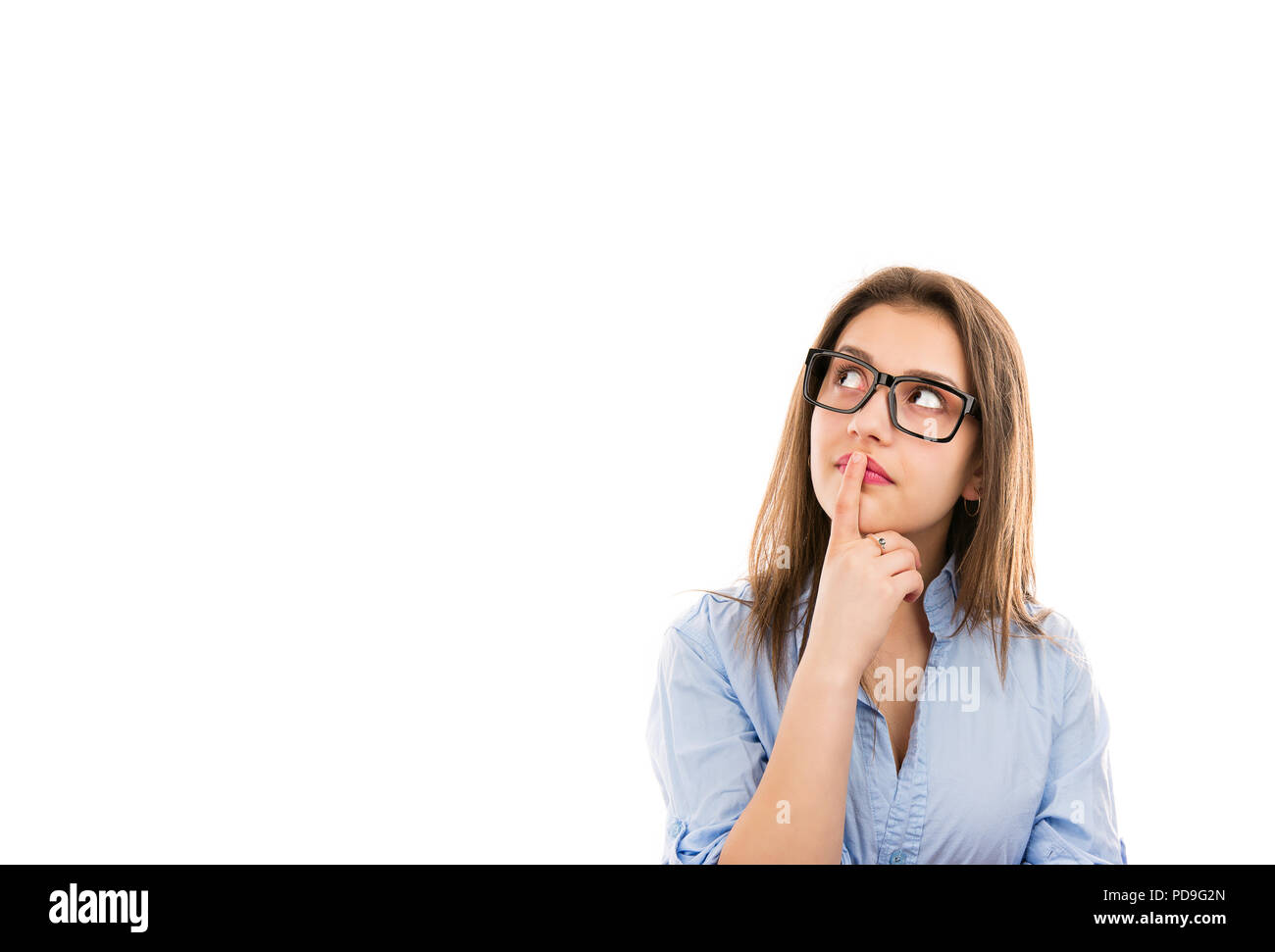 Young thinking woman in glasses touching lips and looking up contemplating on idea isolated on white background Stock Photo