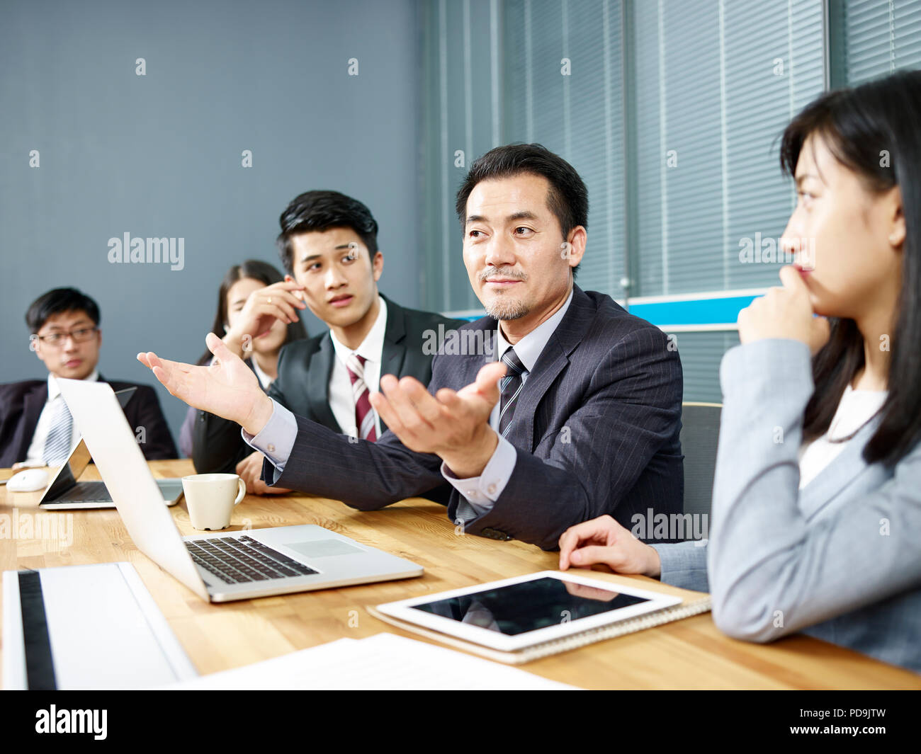 asian corporate executive and his business team meeting and negotiating with client. Stock Photo