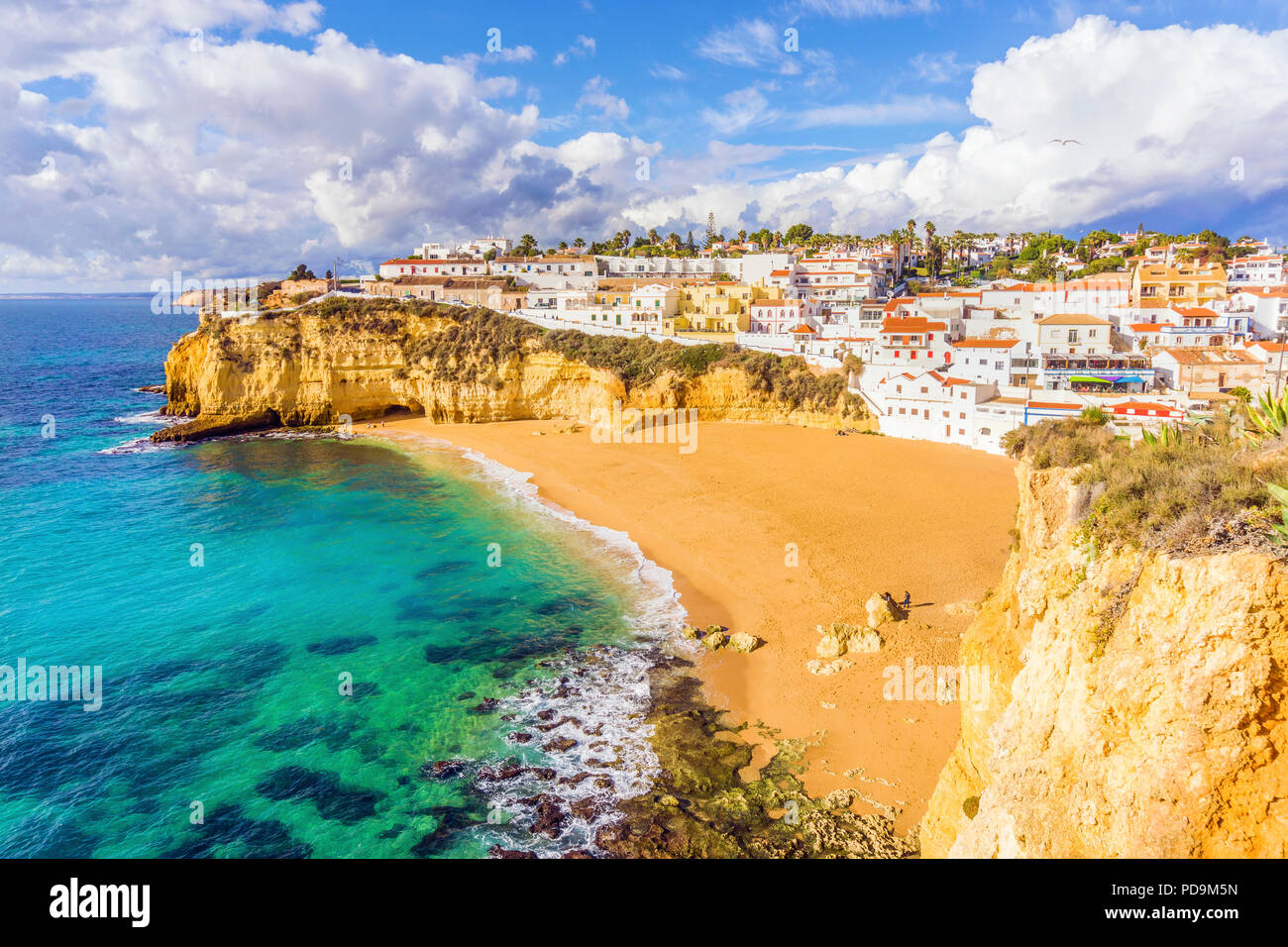 Wide sandy beach, white houses, cloudy sky, Carvoeiro, Algarve, Portugal Stock Photo