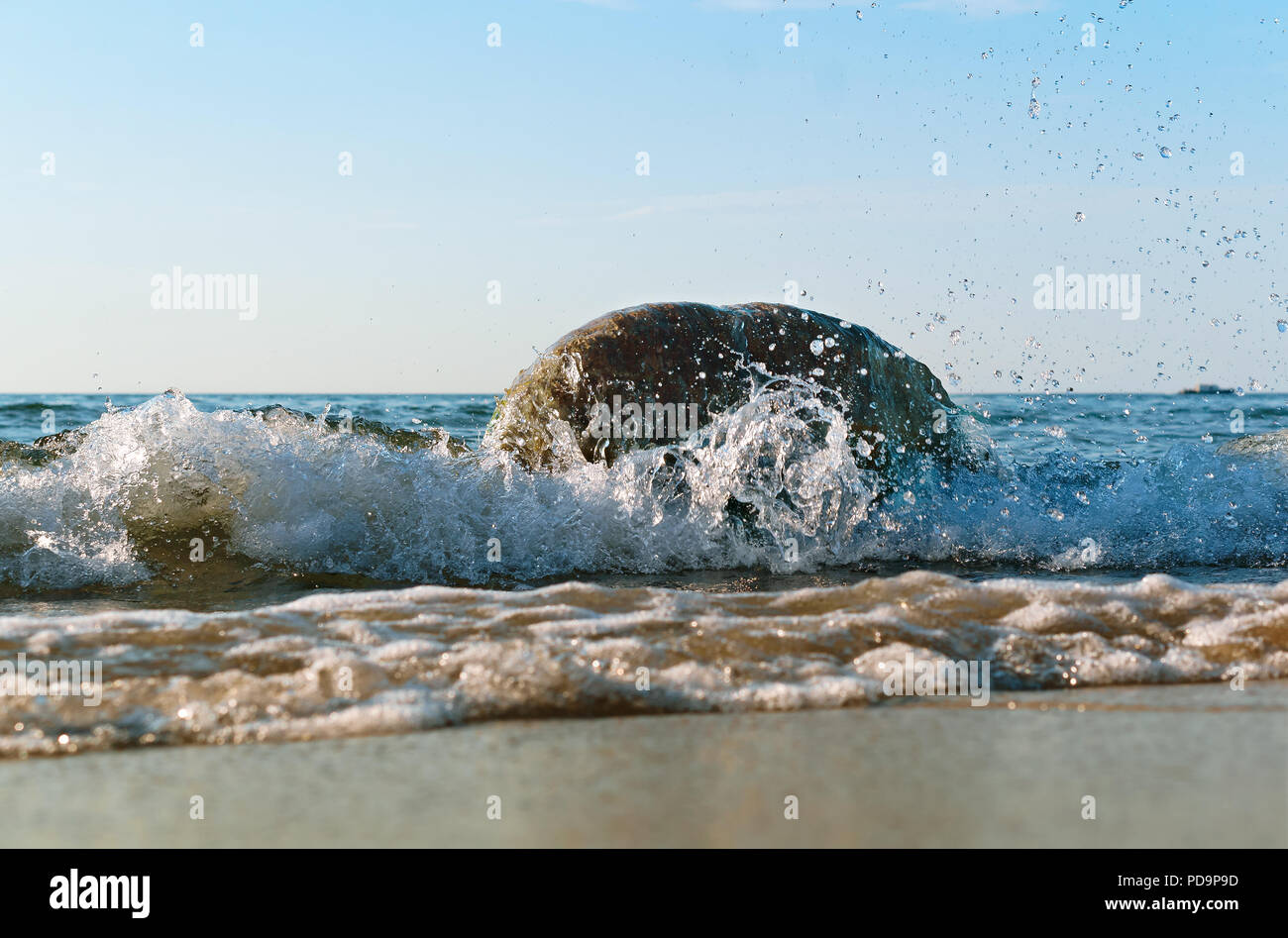 the sea wave hits the shore, the waves break on the coastal rocks Stock