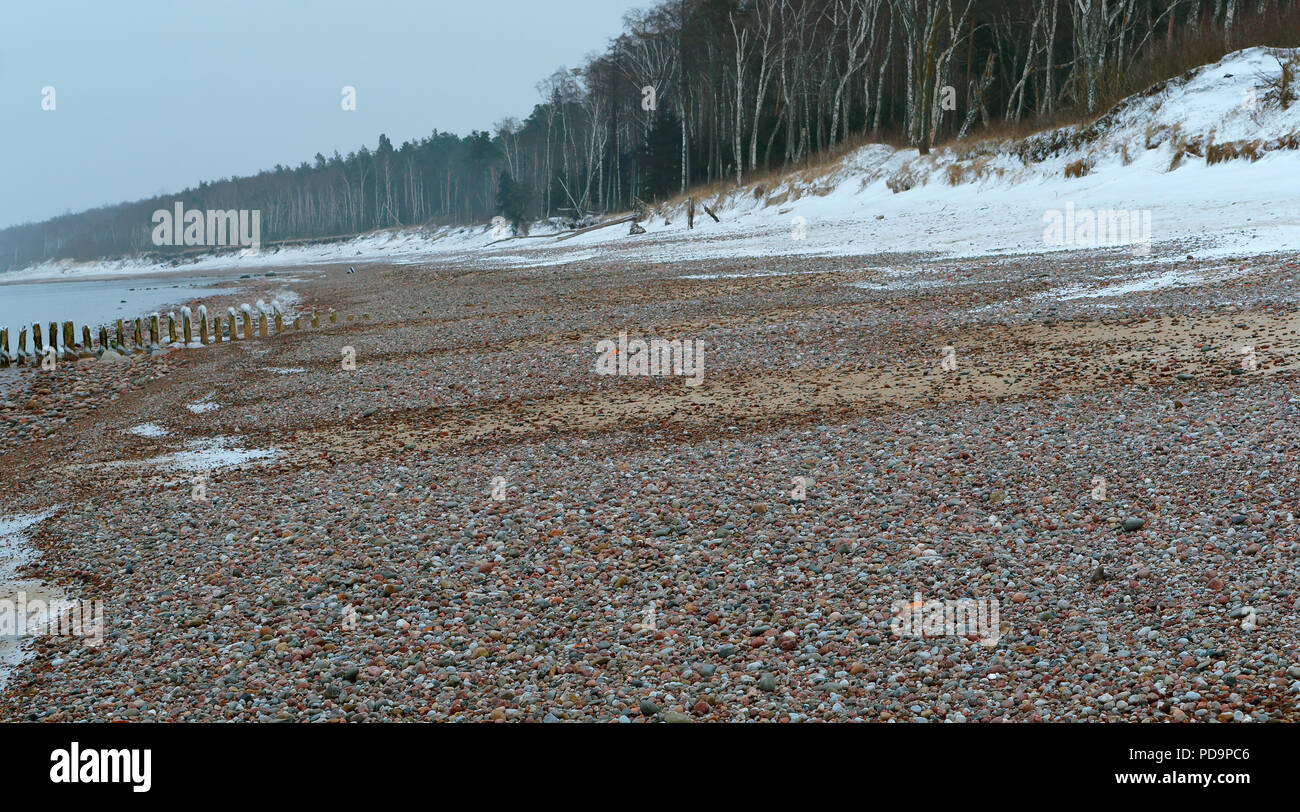 sea coast in stones, wide rocky beach of the sea in winter Stock Photo