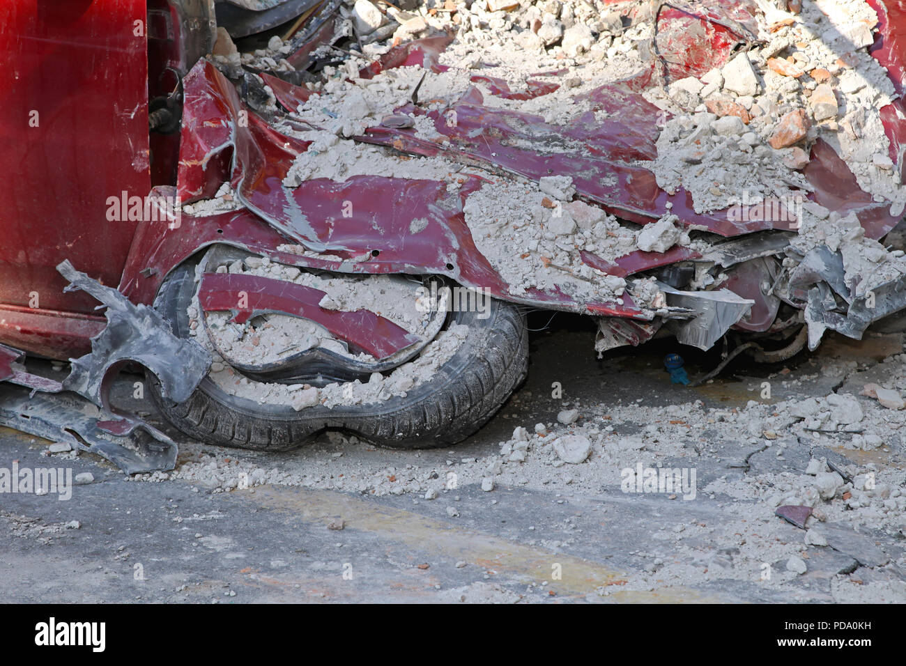 Unrecognizable small red car after facade fall off Stock Photo - Alamy