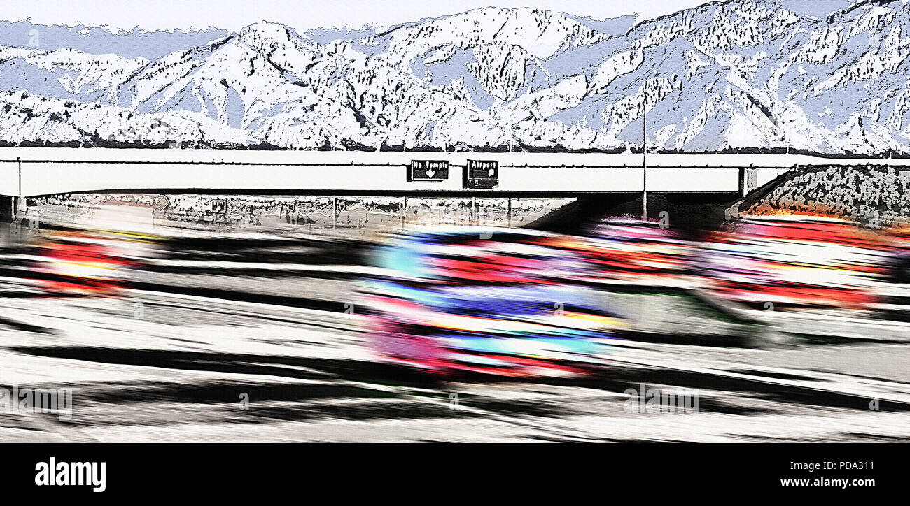 Cars speed down the freeway (I -80) in Salt Lake City, Utah, USA. You can see the Wasatch mountain range in the background. The cars are blurred to ac Stock Photo