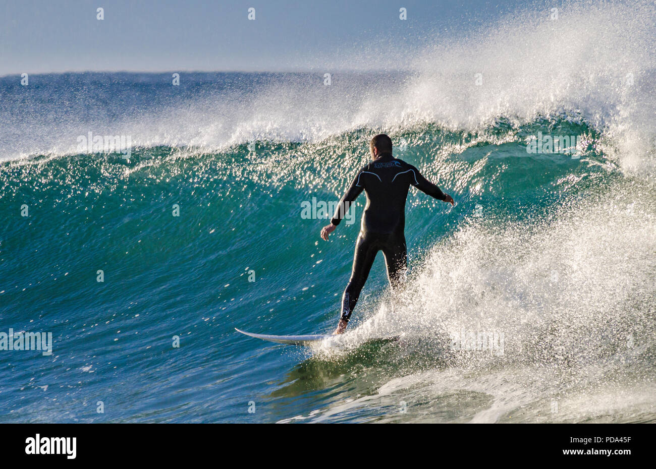 Surfer wearing wetsuit riding a righthand wave Stock Photo Alamy