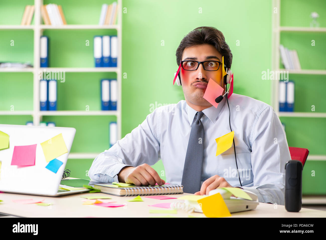 Young help desk operator working in office with many conflicting