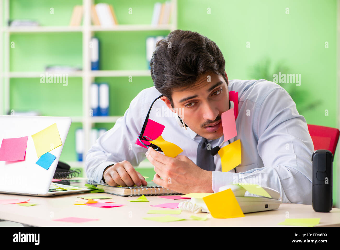 Young help desk operator working in office with many conflicting