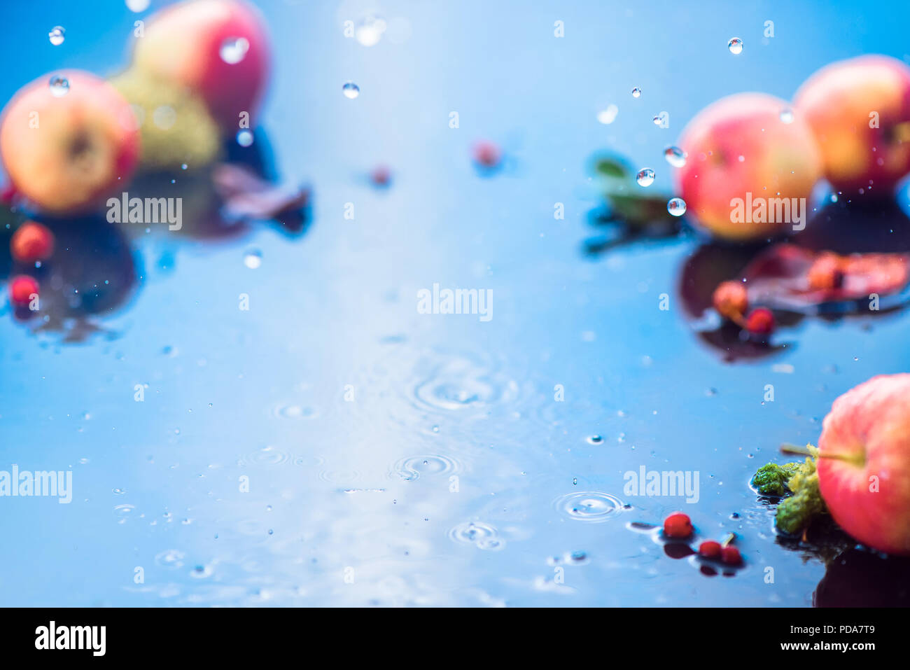 Autumn rain frame with copy space. Unfocused apples with water drops and place for text. Fresh and airy autumn harvest concept Stock Photo