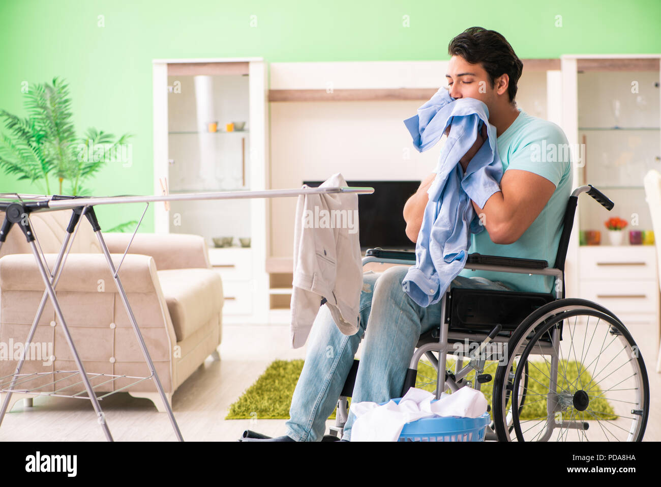 Disabled man on wheelchair doing laundry Stock Photo