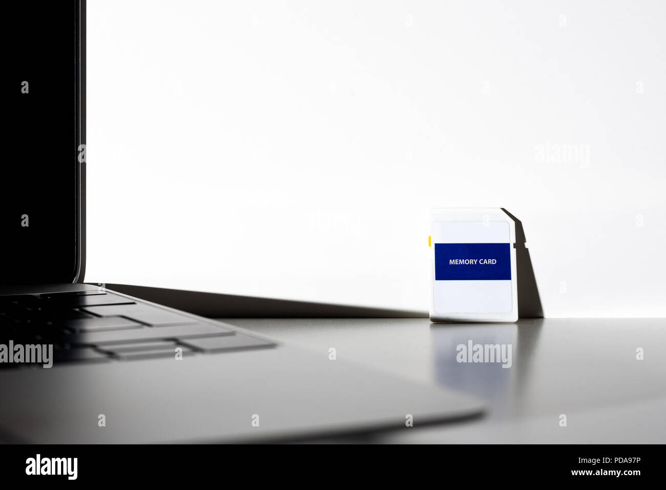 Memory card with empty surface next to a notebook computer. Concept SD