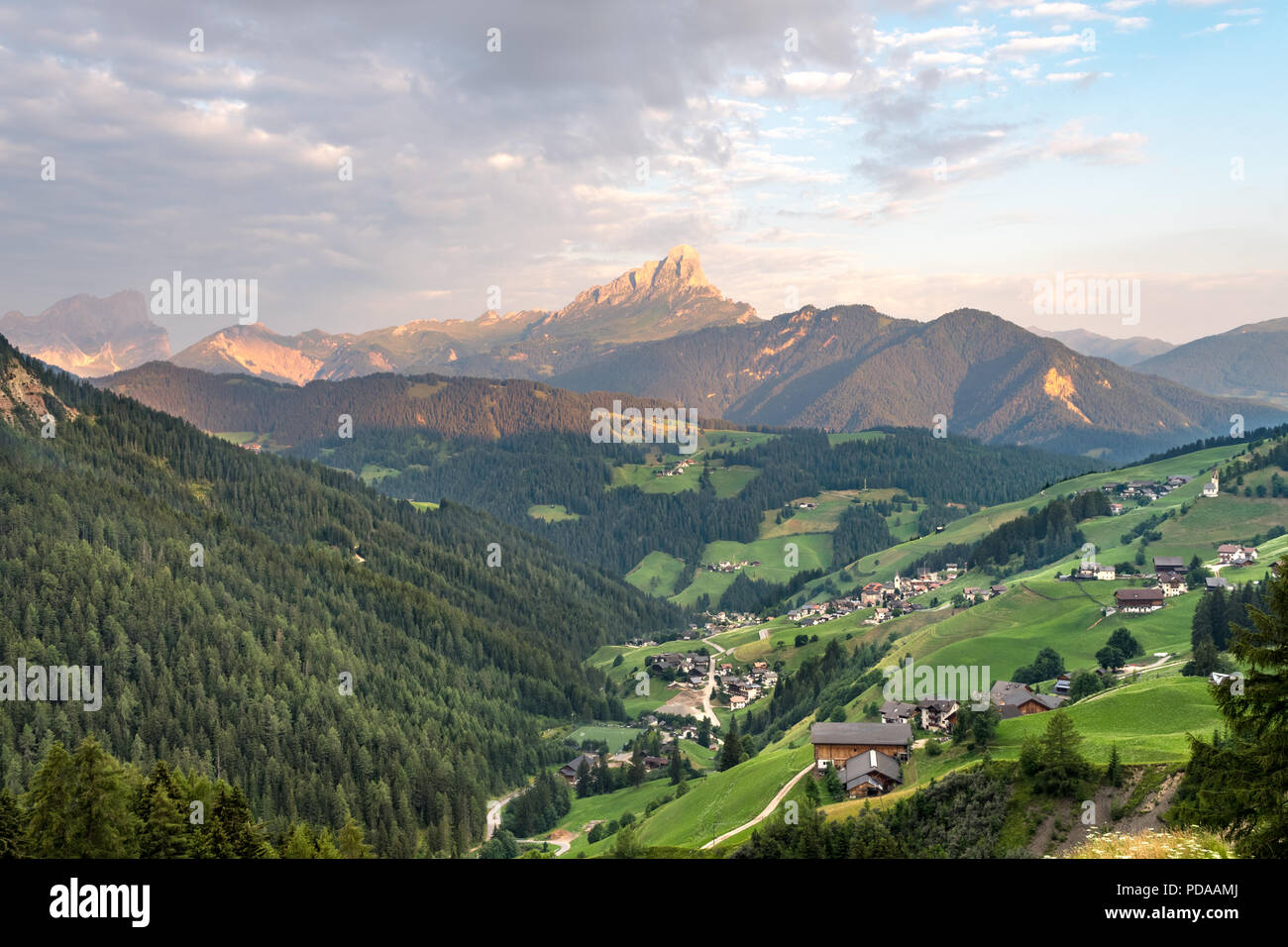 Morning mountain landscape during sunrise in the Dolomites in South Tyrol: sunlit mountain peak called Peitlerkofel seen from a valley in La Valle Stock Photo