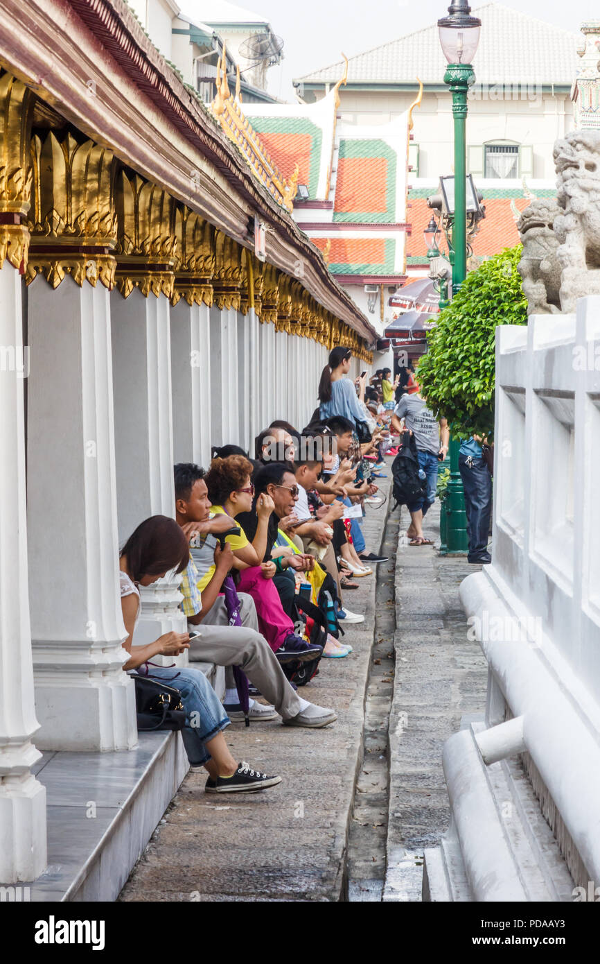 Bangkok, Thailand - 30th November 2014: Chinese tourists taking a break at the Grand Palace. Millions of Chinese come to Thailand each year. Stock Photo